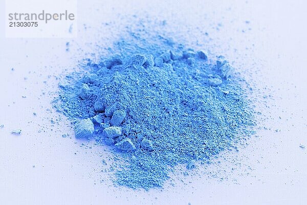 Blue color background of chalk powder. Blue color dust particles splattered on white background