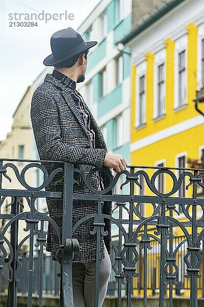 Portrait of a stylish handsome young man with a coat outdoors. A man wearing a coat and a shirt looking away and wondering