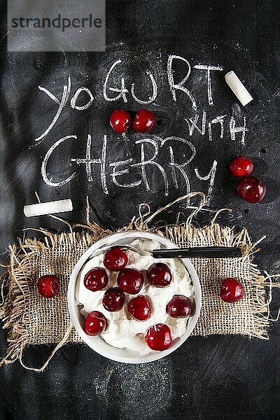 Presentation of desserts made with yogurt and cherries on a black background