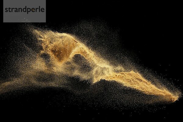 Dry river sand explosion.Brown color sand splash against black background