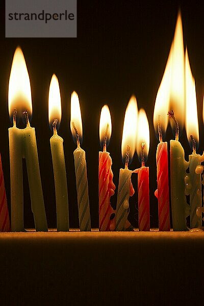 Series of small lighted candles on a black background