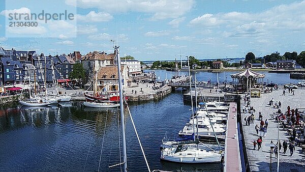 Aerial view of the yachts and bridge in old harbor in Honfleur  a resort and ancient town in Normandy  people walking in distance. (unrecognizable persons)