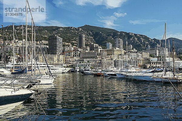 Awe Morning view on boats and yachts (sailboats) in Hercule port and buildings of Monaco and Monte Carlo in right direction with hotels and casino buildings. Mountains above buildings  Fantastic summer for recreation  vacations and travel