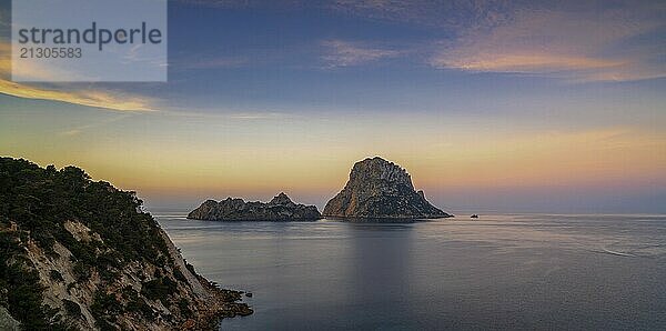 A panorama landscape view of the landmark Es Vedra island and rocks off the coast of Ibiza at sunrise