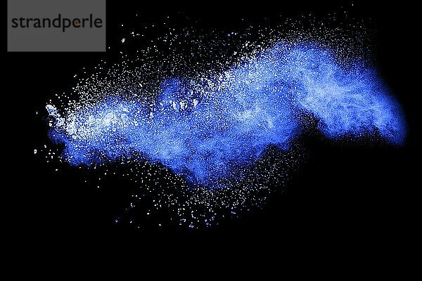 Blue color powder explosion cloud on black background.Closeup of Blue dust particles exhale on dark background