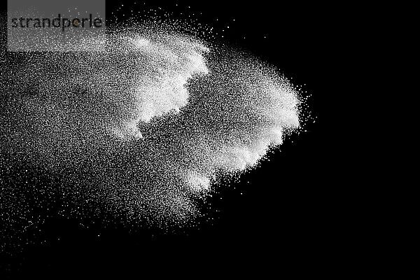 White powder explosion cloud against black background.White dust particles splash