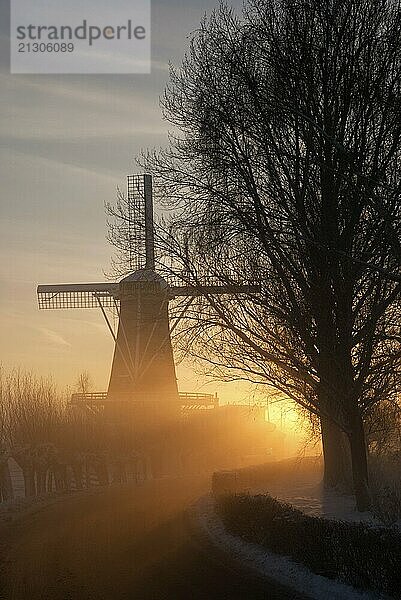 Wintery view at mill de Hoop near Oud-Alblas across the frozen river Graafstroom in the Dutch region Alblasserwaard