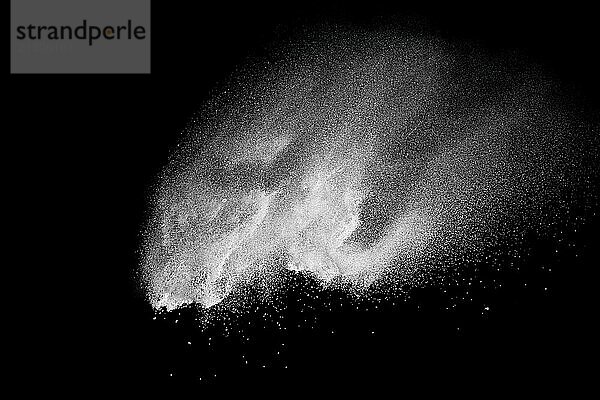 Bizarre forms of white powder explosion cloud against black background.White dust particles splash