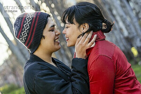 Lesbian couple smiling and leaning in for a kiss