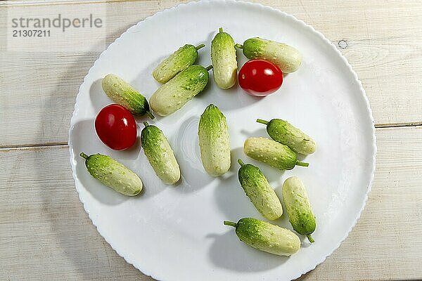 Small cute cucumbers (in the winter  probably greenhouse) in Russia on white wooden table