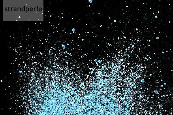 Blue color background of chalk powder. Blue color dust particles splattered on black background