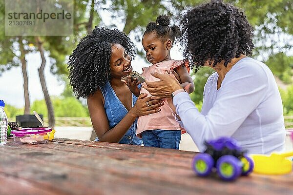 African mother and granmother playing with cute african girl in the park