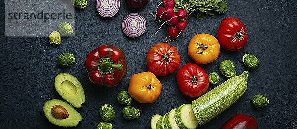 Selection of fresh various vegetables  cut zucchini  greenery on rustic dark background top view. Cooking vegetarian meal from healthy ingredients  diet food and nutrition concept  food photography  food photography