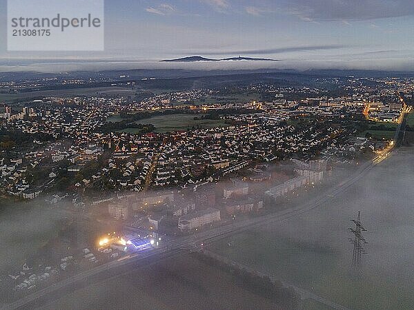 Fog rolls in over the Oberursel district of Weißkirchen  near Frankfurt am Main  in the morning  while the Taunus ridge with the Großer Feldberg and the Altkönig protrude from the clouds on the horizon. (Aerial view with a drone)  Weißkirchen  Hesse  Germany  Europe