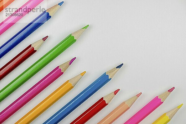 Abstract composition of a set wooden colour pencils against a white background