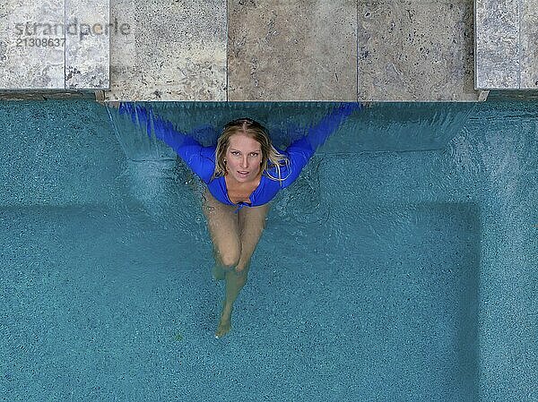 A gorgeous blonde bikini model enjoys a day by the pool at home