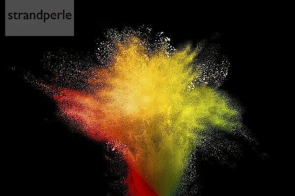 Abstract yellow orange powder explosion on white background. Freeze motion of yellow orange dust particles splash