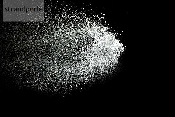 Bizarre forms of white powder explosion cloud against black background.White dust particles splash