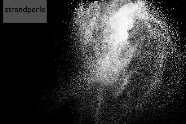 Bizarre forms of white powder explosion cloud against black background.White dust particles splash