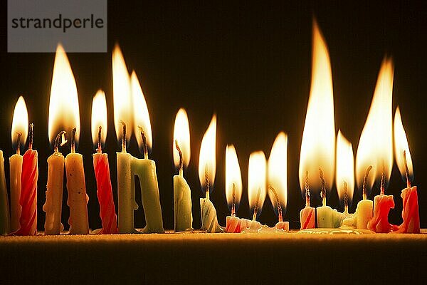 Series of small lighted candles on a black background