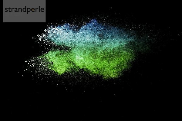 Launched blue green color powder explosion on black background