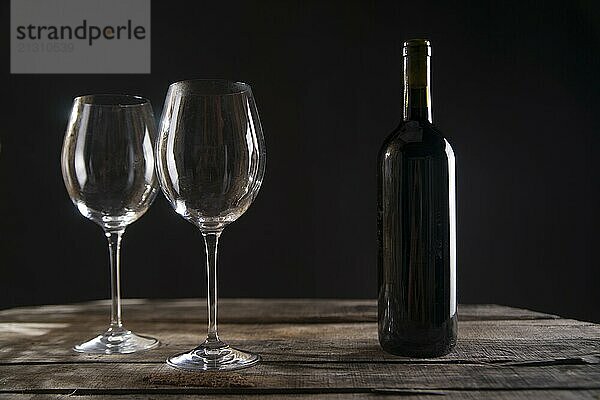 A bottle of red wine glass in dark background