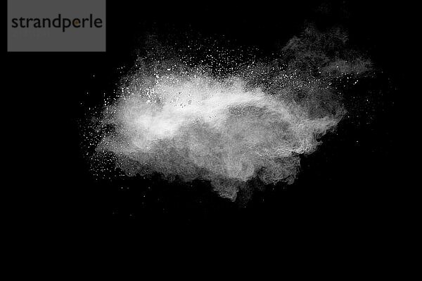 White powder explosion cloud against black background.White dust particle splash