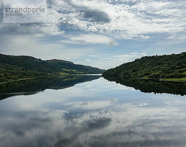 A landscape view of Glencar Lough in western Ireland with sky reflections in the calm lake water