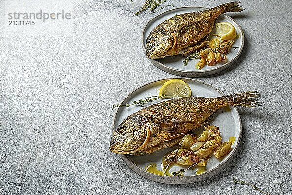 Food  Food  Grilled sea bream or dorada on gray plate. Gray background