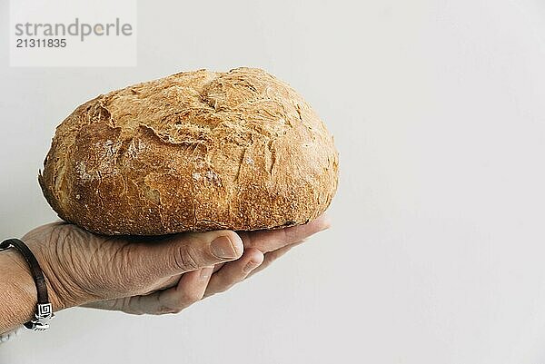 Woman hands holding a loaf of bread isolated on white background