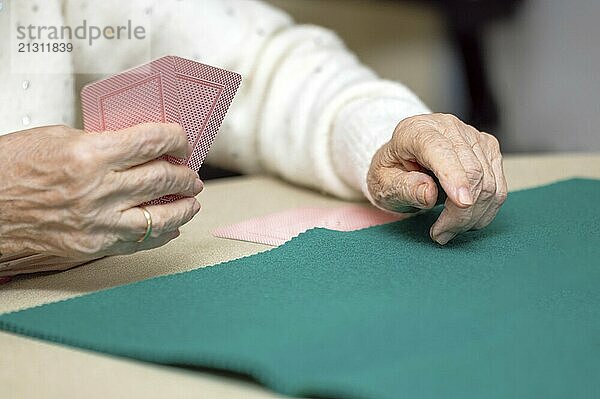 Active retirement  group of elderly women having fun playing cards game at nursing home. graphy