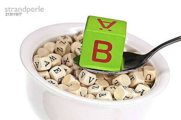 Vitamin-rich alphabet soup with vitamin B  against a white background