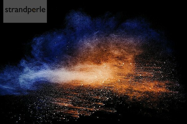 Orange blue powder explosion on black background.Orange blue color dust splashing