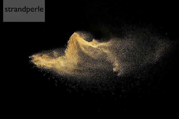 Dry river sand explosion.Brown color sand splash against black background