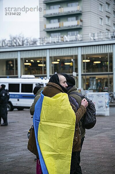 24.02.2023  Berlin  Germany  Europe  Three participants stand tightly embraced in front of Café Moskau  which was briefly renamed Café Kyiv  ahead of the opening rally of a protest event on Karl-Marx-Allee. On the anniversary of the start of Russia's war in Ukraine  a peaceful demonstration with several thousand Ukrainians and activists is taking place in Berlin's Mitte district under the slogan  Europe