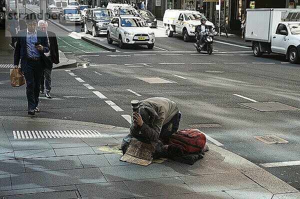 19.09.2018  Sydney  New South Wales  Australia  A homeless man kneels on a pavement in the city centre and begs for a donation  Oceania