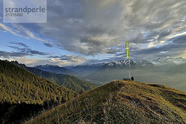 Sitting woman enjoying a dreamlike evening mood in the mountains  view to the Rätikon  flag of the Austrian Alpine Club  Frassenhütte  Vorarlberg  Austria  Europe