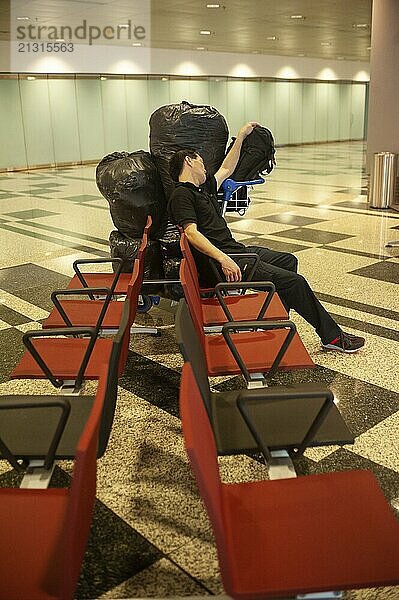 01/03/2019  Singapore  Republic of Singapore  Asia  A passenger sleeps next to his luggage in a public area of Terminal 3 at Singapore Changi International Airport  Asia