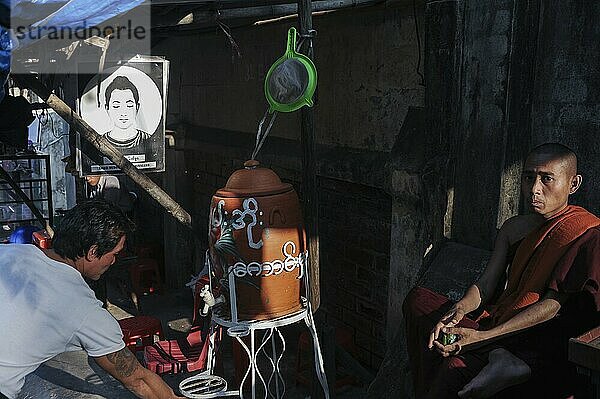 20.01.2014  Yangon  Myanmar  Asia  A Buddhist monk sits at a roadside stall  Asia