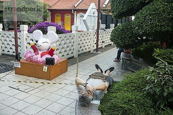 23.01.2020  Singapore  Republic of Singapore  Asia  A man sleeps in a small public park overlooking New Bridge Road and Eu Tong Sen Street in the Chinatown neighbourhood  Asia