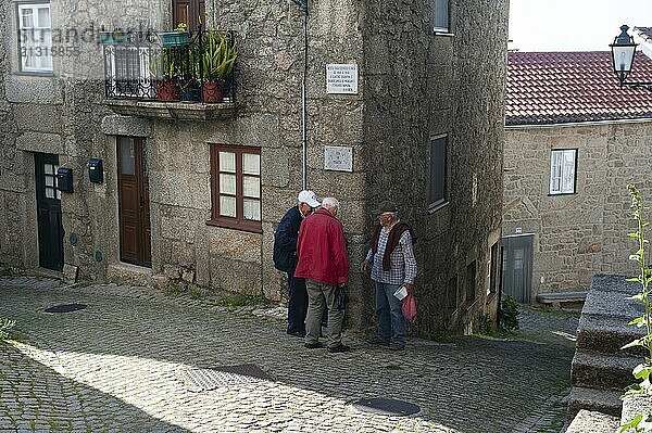 12/06/2018  Monsanto  Portugal  Europe  Three elderly men talk in front of a house in the mountain village of Monsanto  Europe