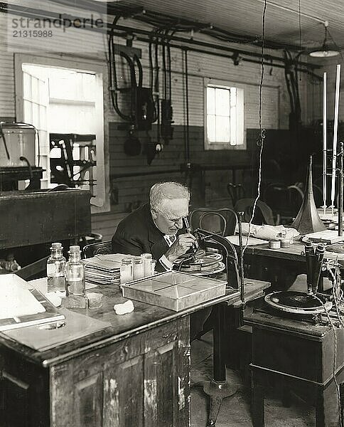 Thomas Alva Edison examining a phonograph disc under a microscope  digitally edited