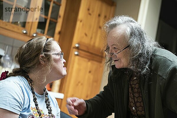 Hakendover  Flemish Brabant  Belgium  09 20 2021: Disabled 39 year old woman and her 83 year old mother having fun in the kitchen at home  Europe