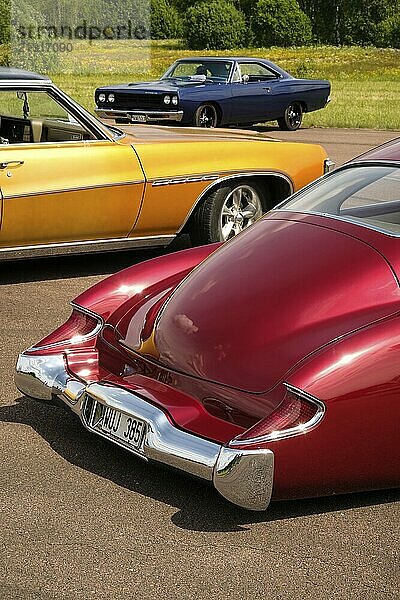 Three American vintage cars  red gold-coloured and blue  in front the rear part of a red Buick Super Sedanette from 1949  Värmland  Sweden  Europe