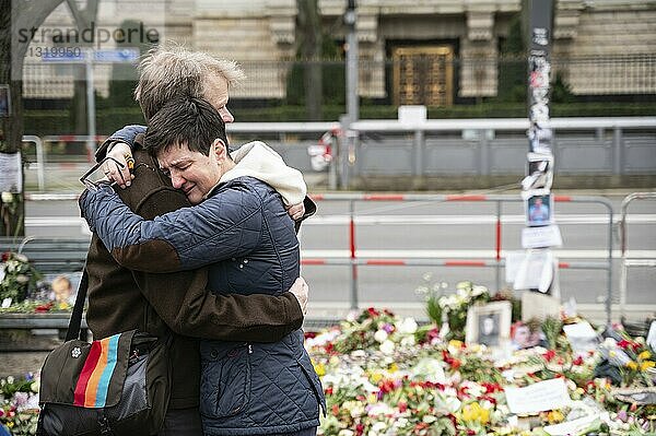 24.02.2024  Berlin  Germany  Europe  Mourners embrace at an improvised memorial of flowers  candles and pictures for Russian opposition leader Alexei Navalny in front of the Russian embassy on Unter den Linden in Berlin's Mitte district. After his imprisonment and many years in Russian prisons and penal camps  the Russian prison administration announced his death on 16 February 2024  Europe