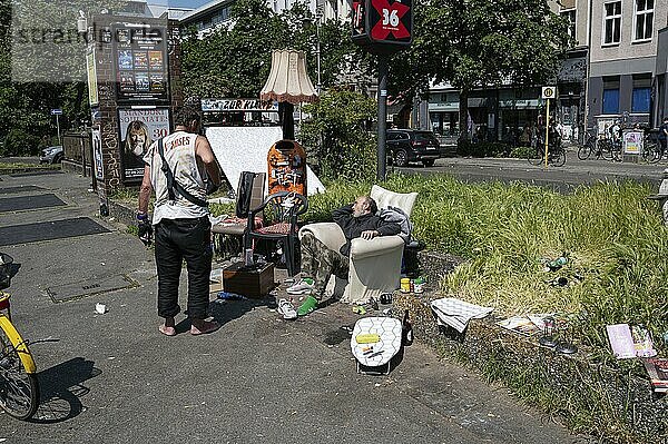 28.05.2023  Berlin  Germany  Europe  Two homeless men are staying between discarded pieces of furniture at a crossroads in the Kreuzberg district of Berlin  Europe