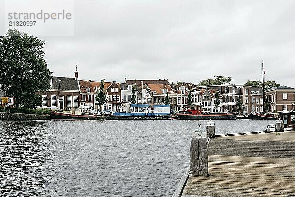 Haarlem  Netherlands  August 3  2016: Picturesque cityscape with beautiful traditional houses and vessels in canal of Haarlem