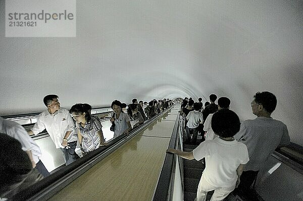 09.08.2012  Pyongyang  North Korea  Asia  Commuters on an escalator leading to an underground station in Pyongyang that is accessible to Western visitors. Some of the escalators go more than one hundred metres underground and serve as bunkers in the event of war  Asia