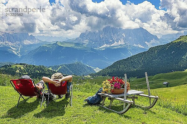 Hikers resting in deckchairs with a beautiful view in the Alps