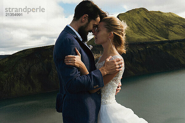 The groom kisses the bride in the mountains of Iceland.